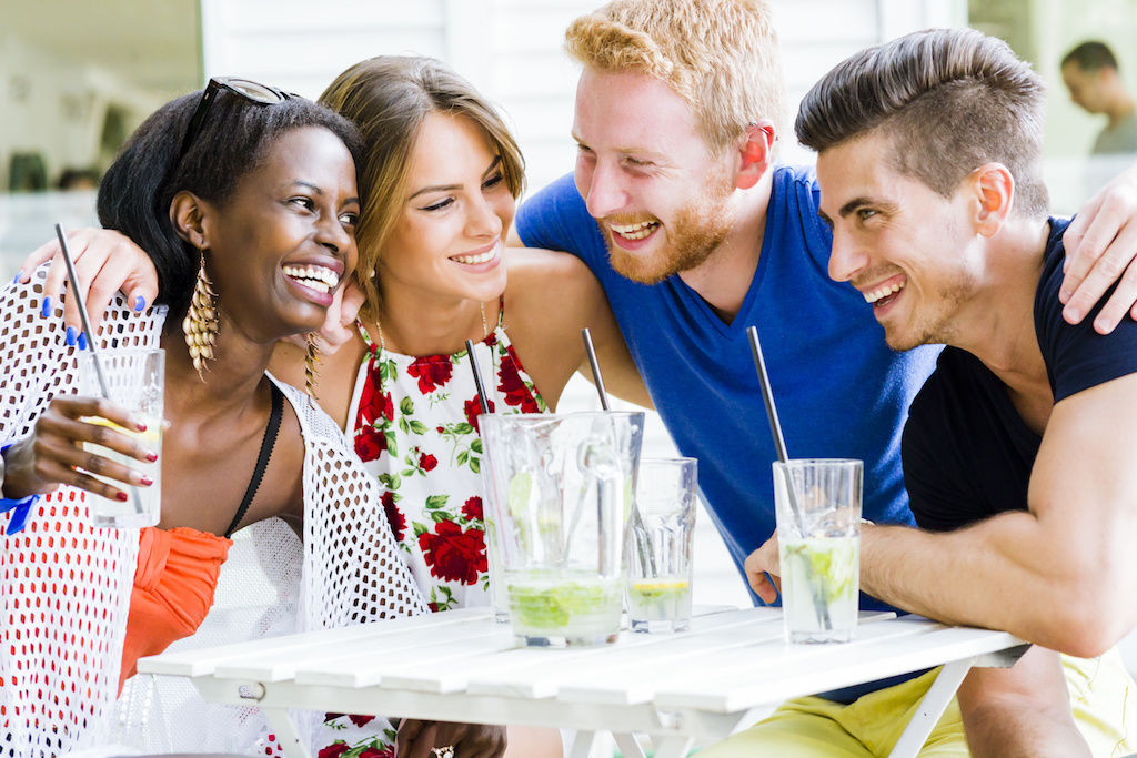 Group of friends laughing around a table